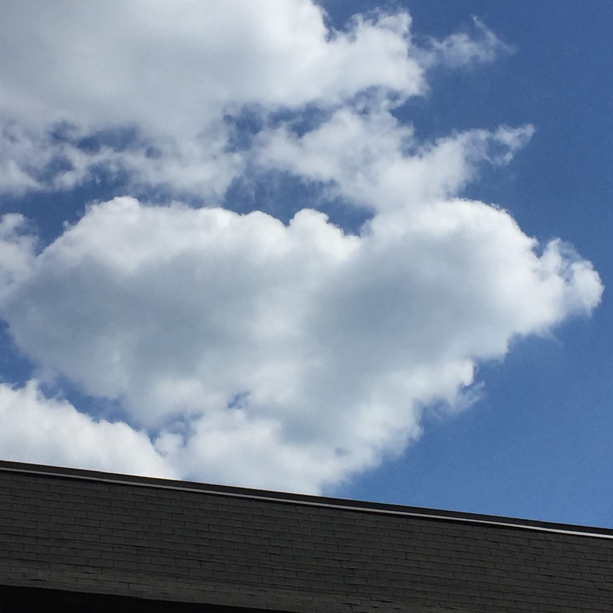 A broad white cloud above a roofline