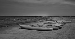 Kayaks beached on a shore at dusk
