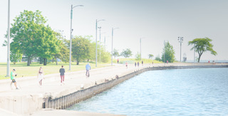 People walking the lakefront promenade on a soft summer day
