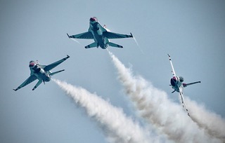 Two Thunderbirds jets crossing in opposite directions